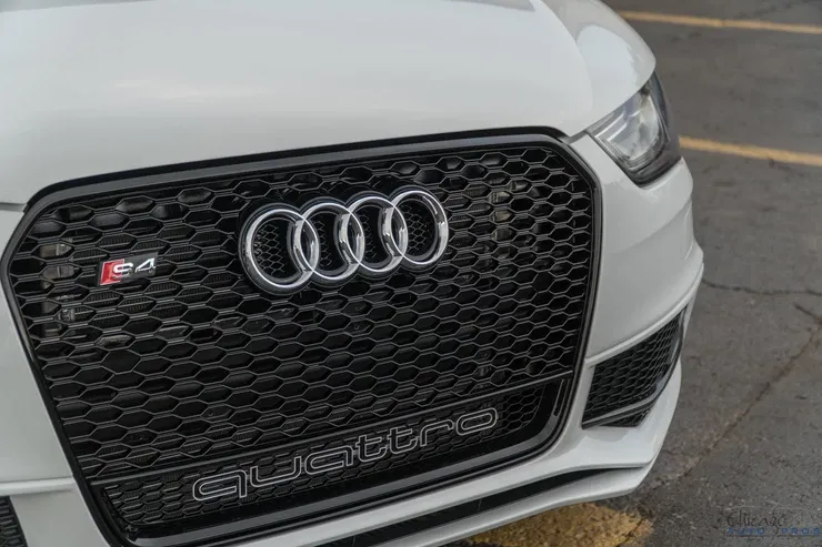 A white audi quattro is parked in a parking lot.