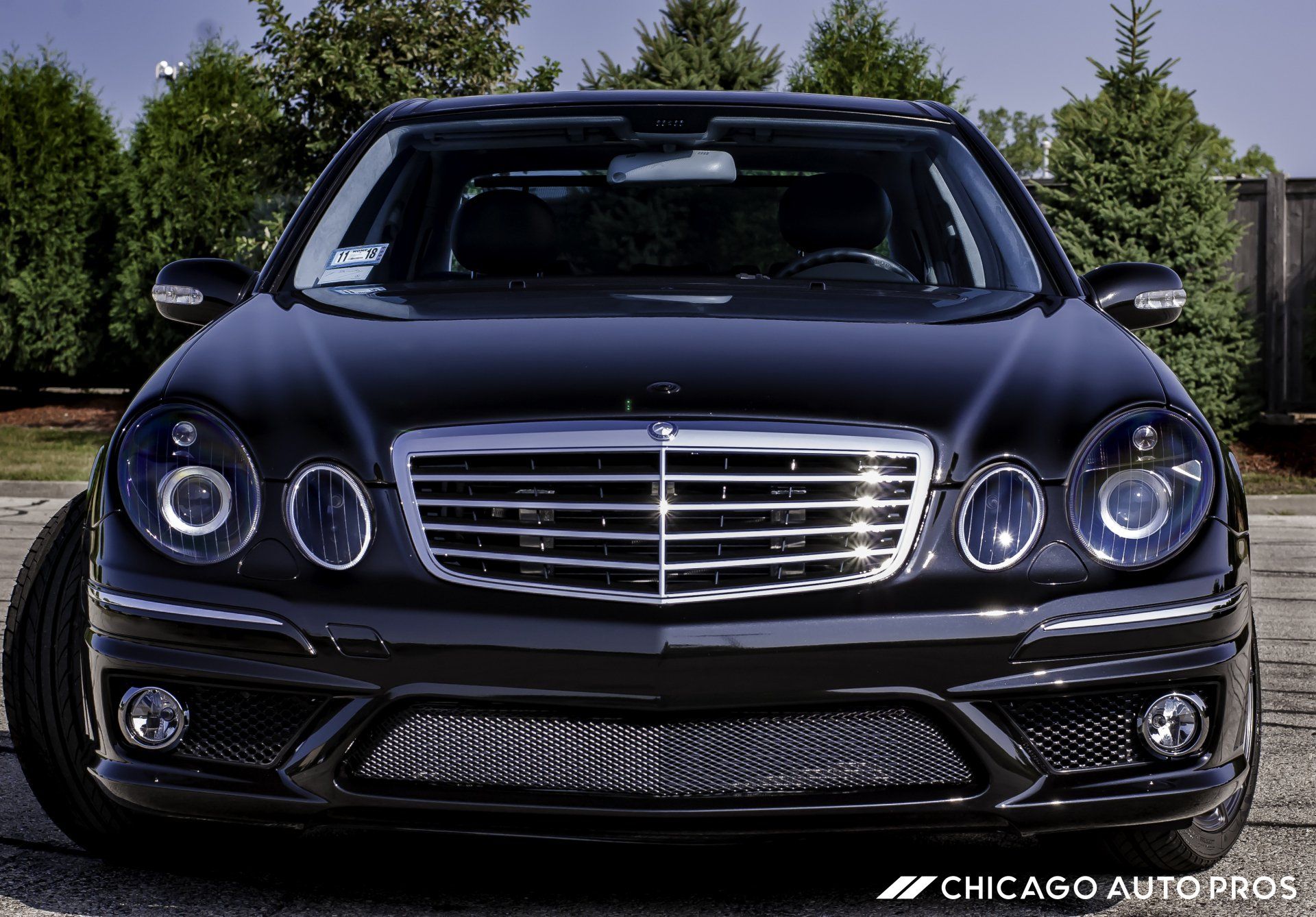 A black mercedes is parked on the side of the road