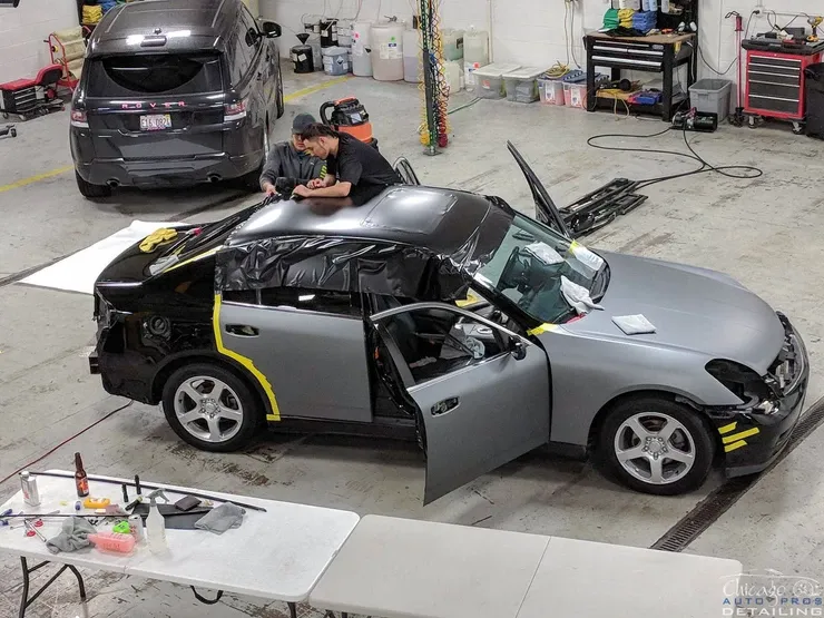 A man is working on a car in a garage.