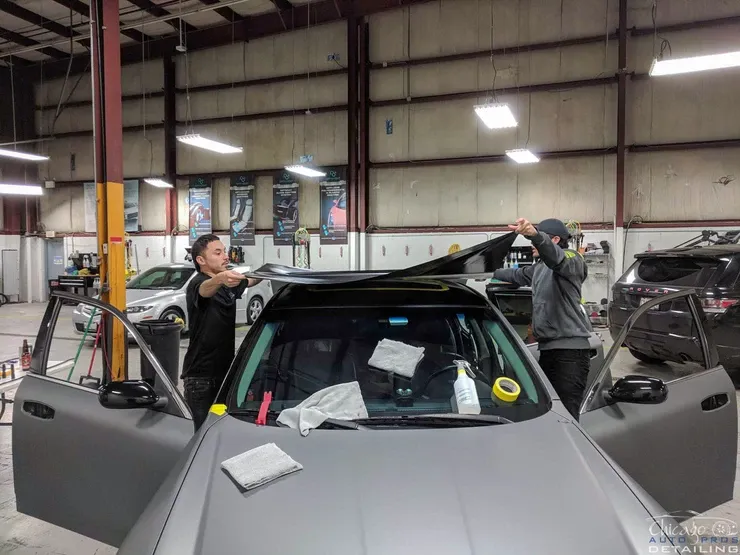 A group of men are working on a car in a garage.