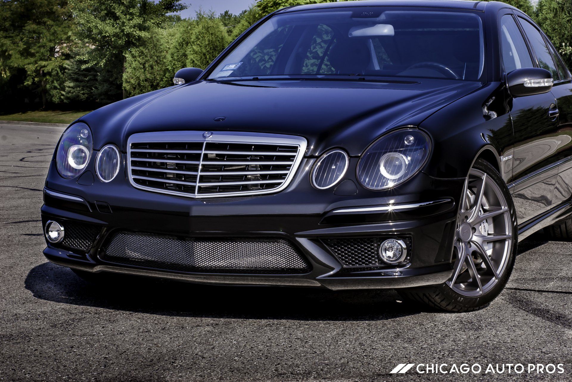 A black mercedes benz is parked in a parking lot