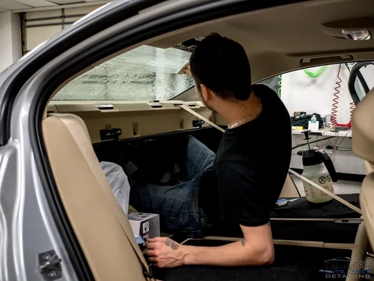A man is sitting in the back seat of a car