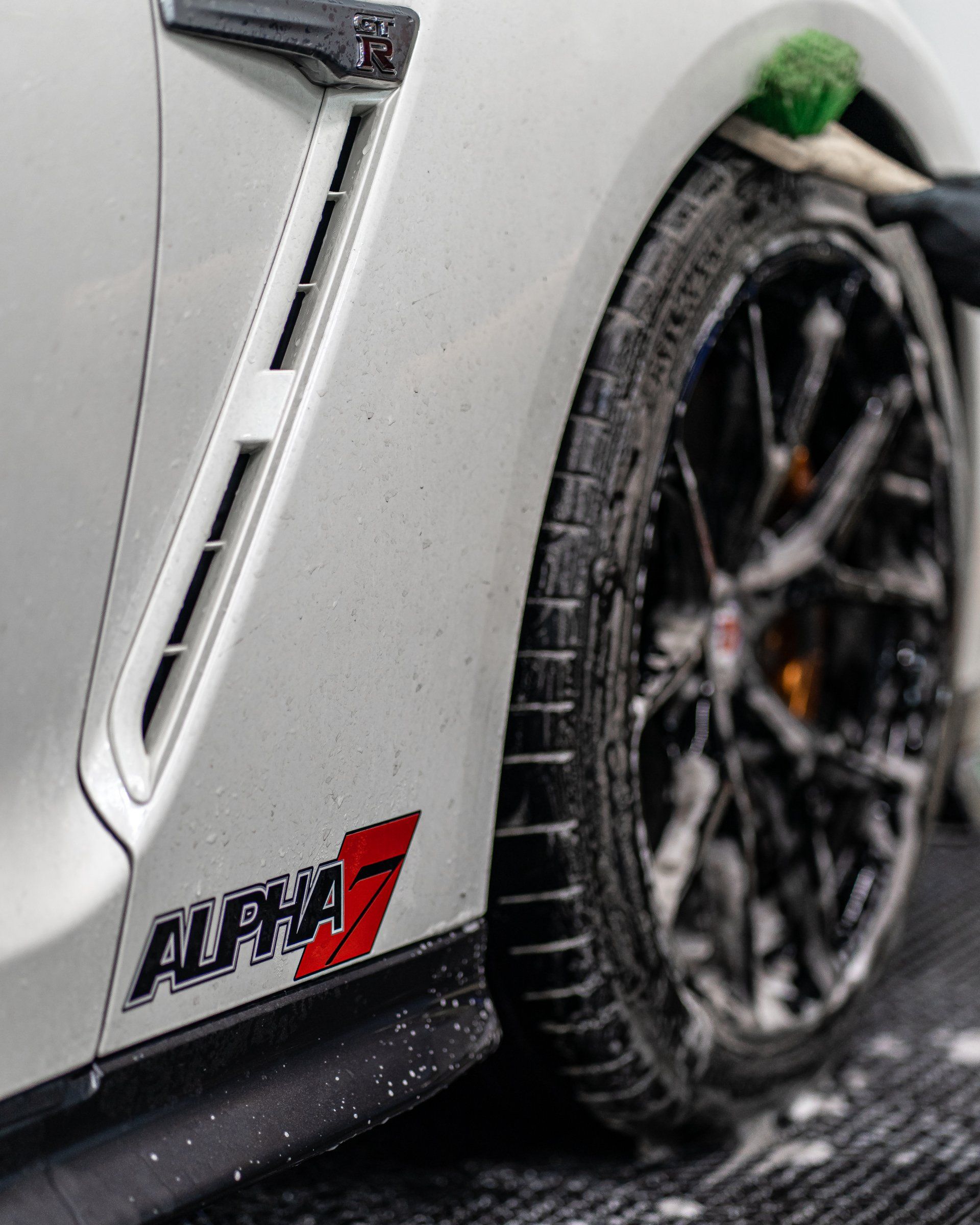 A close up of a white car with the word alpha on the side.