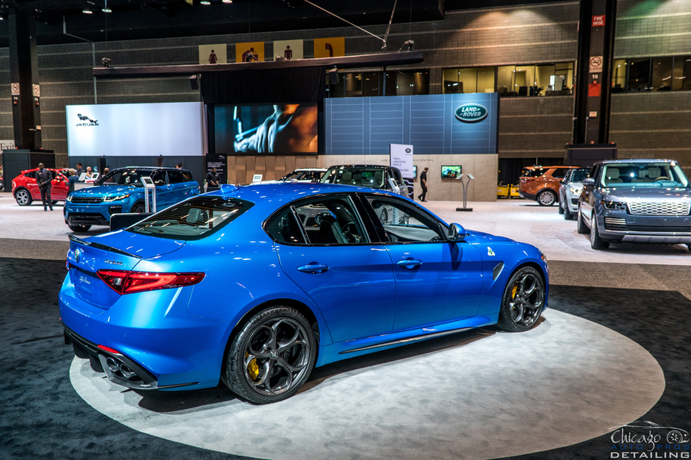 A blue car is on display at a car show