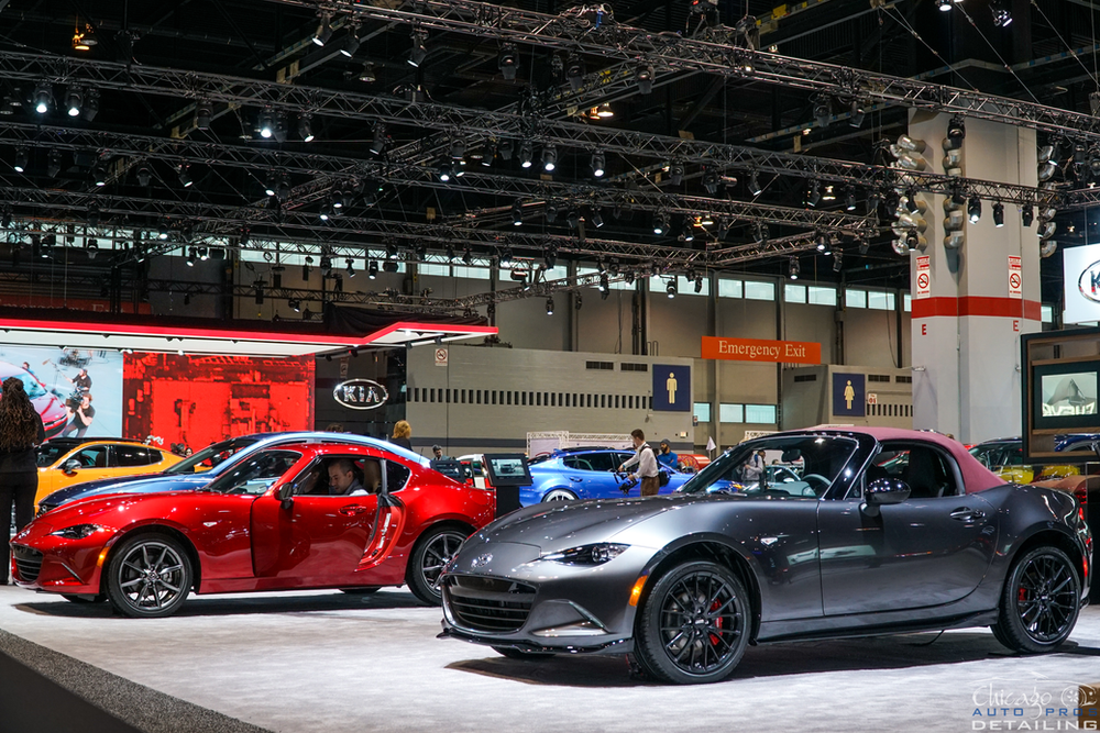 A row of cars are on display at a car show.
