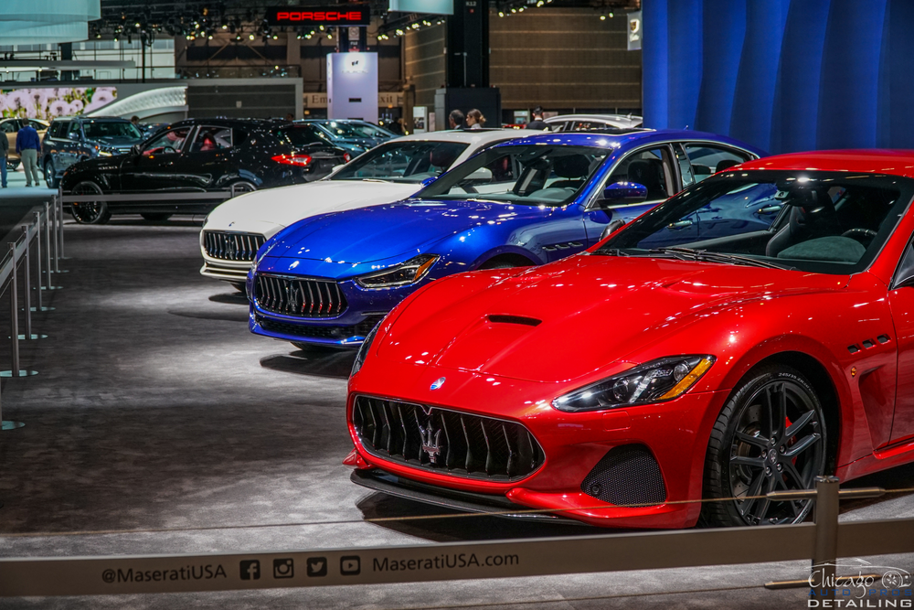 A row of maserati cars are on display at a car show.