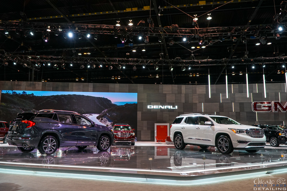 Two gm cars are on display at a car show.