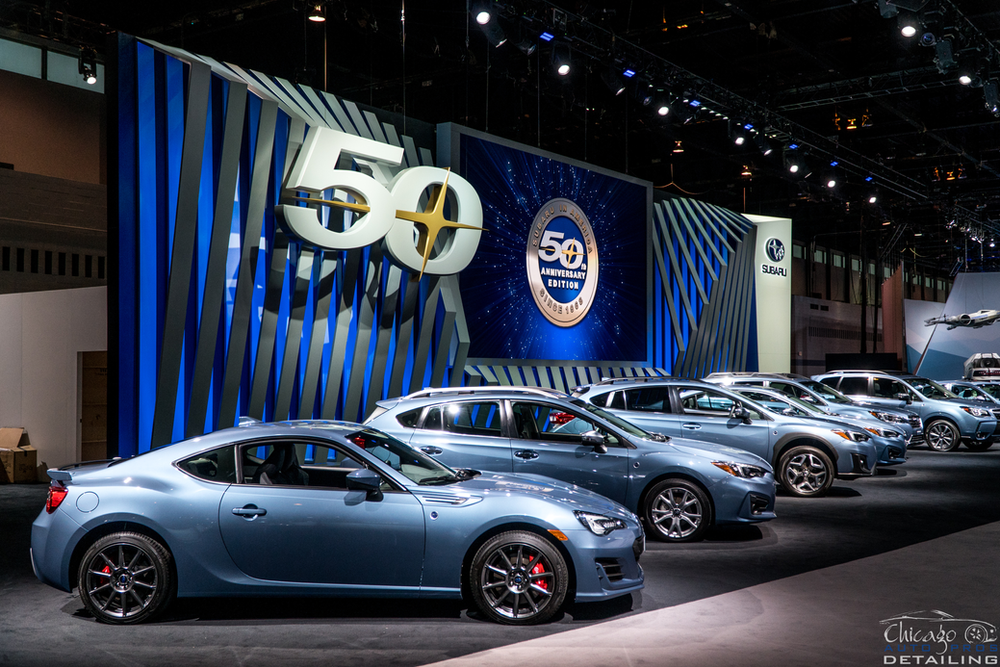 A row of cars are parked in front of a sign that says 50