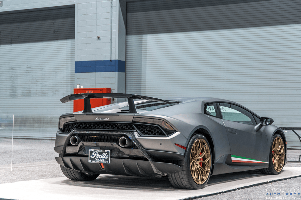 A lamborghini huracan is parked in front of a garage door.