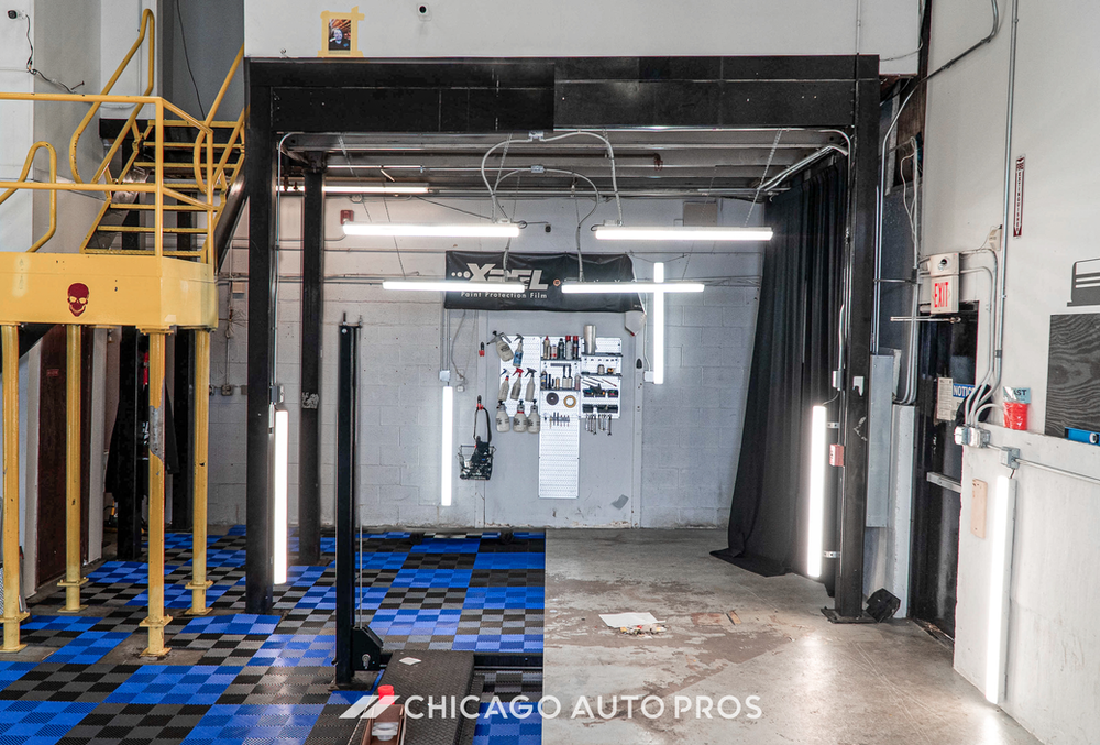 A picture of a car being worked on in a garage.
