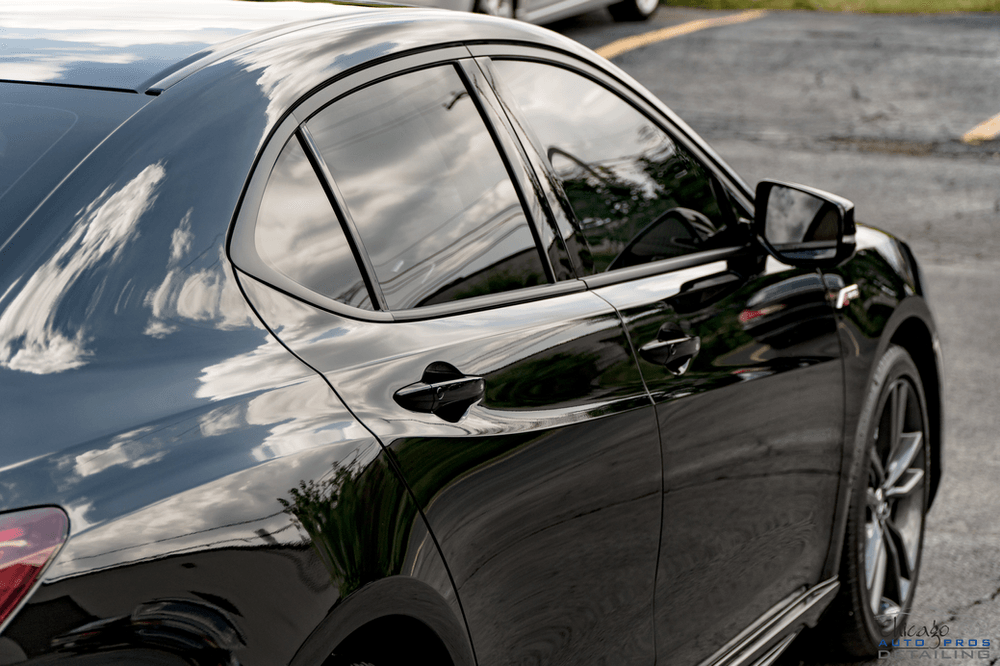 A black car is parked in a parking lot.