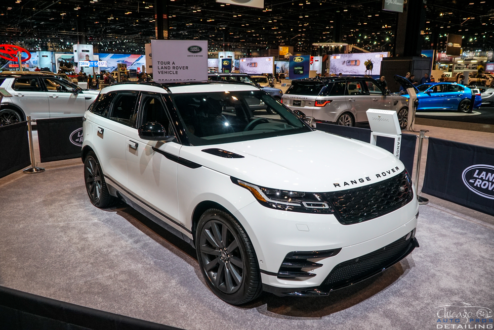 A white range rover velar is on display at a car show.