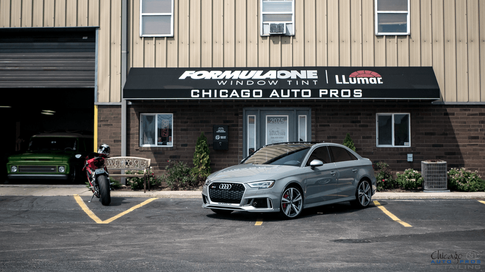 A car is parked in front of a building that says chicago auto pros.