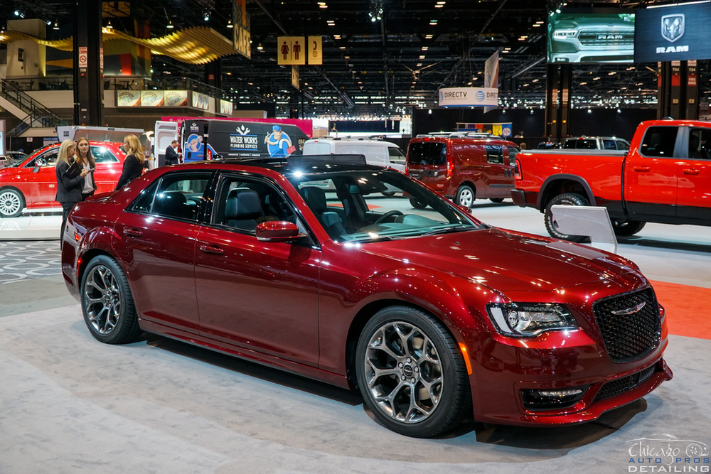 A red car is on display at a car show.