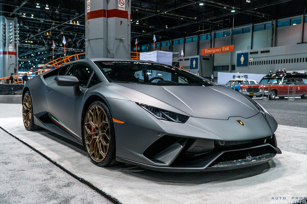 A gray lamborghini huracan is on display at a car show.