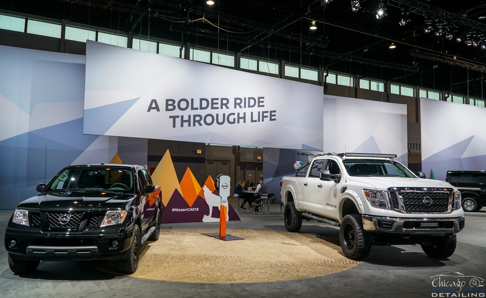 Two trucks are parked in front of a sign that says `` a bolder ride through life ''.