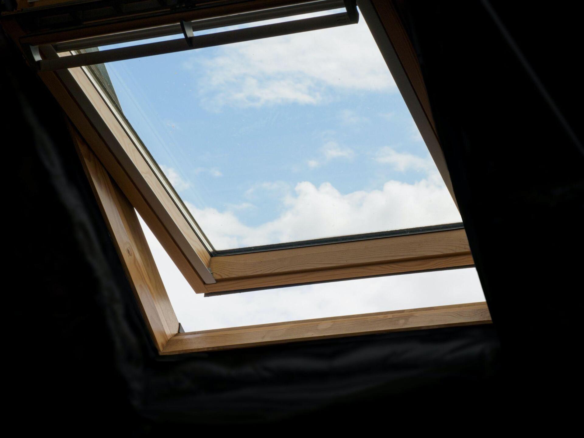 Looking through a skylight at a blue sky with clouds