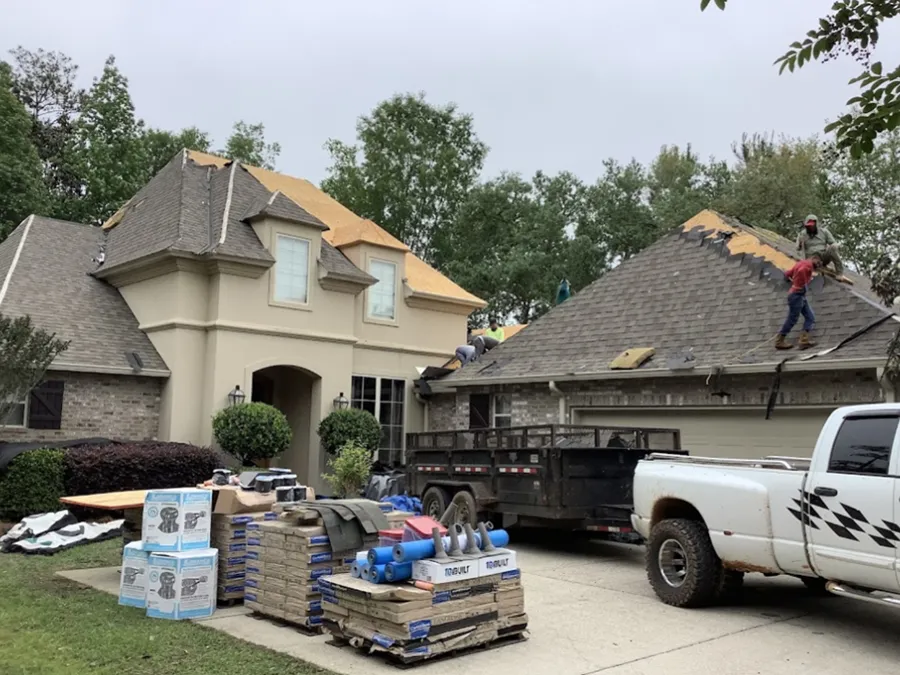 A white truck is parked in front of a house that is being remodeled.