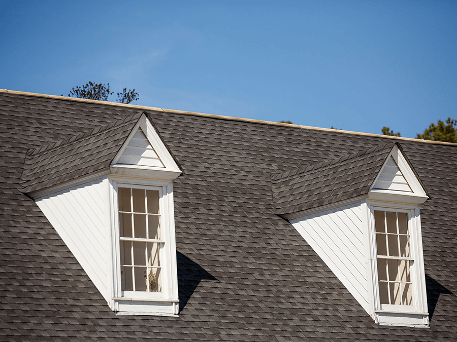 There are two windows on the roof of a house.