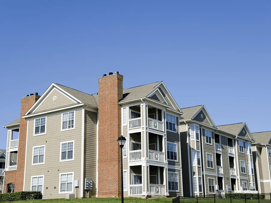 A large apartment building with a blue sky in the background