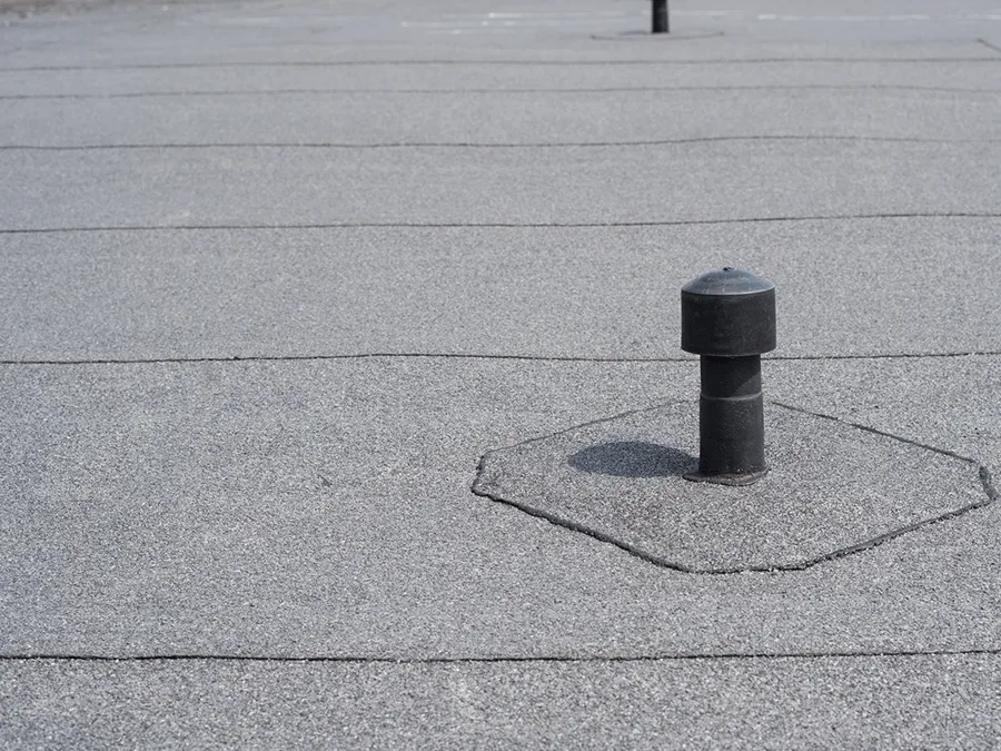 A black pipe is sitting on top of a roof.