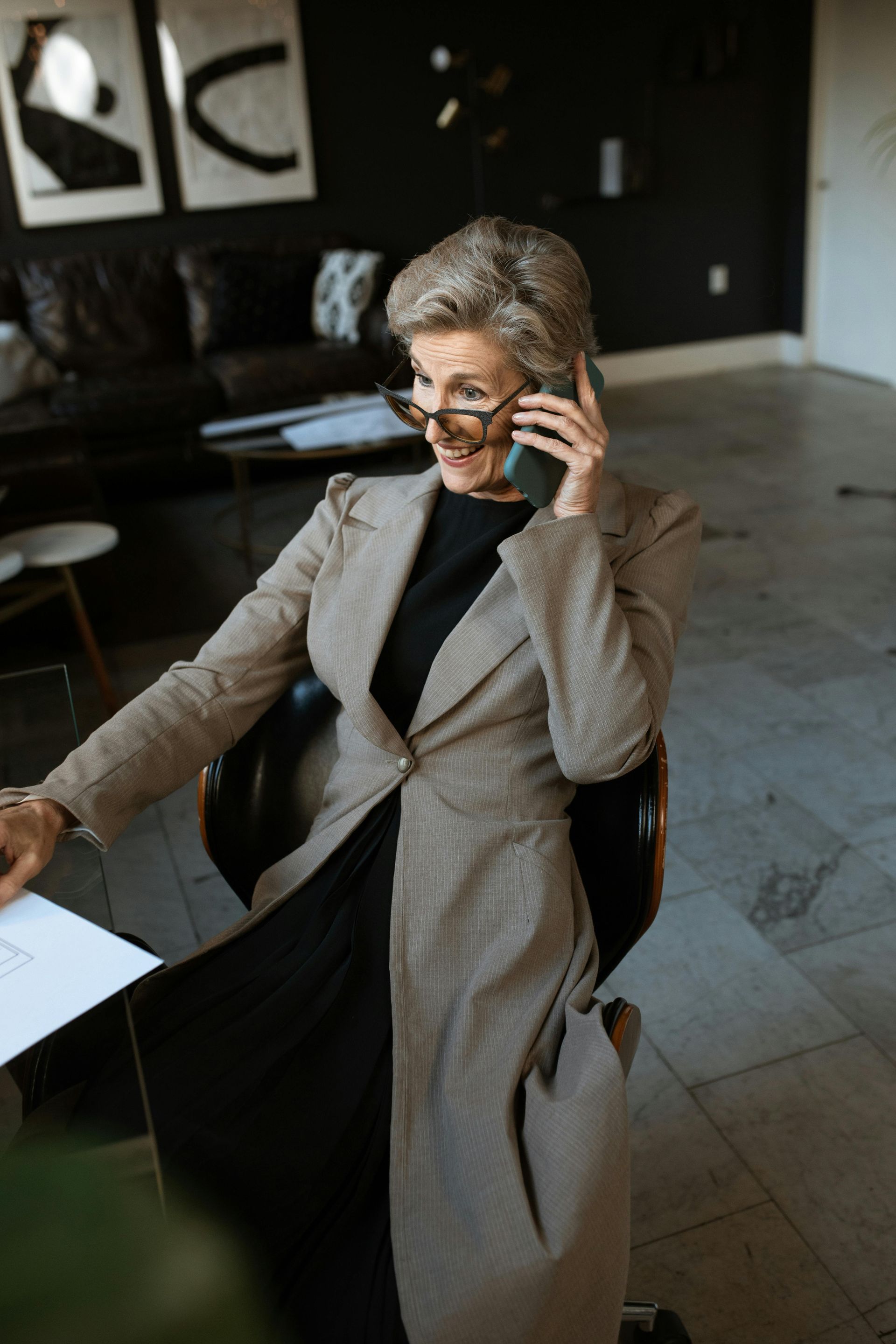 A lady sitting in a chair calling potential clients in order to lock in new business for her company