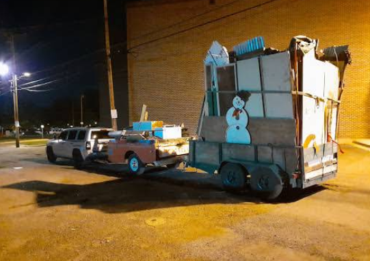 A truck is pulling a trailer with a snowman on it.
