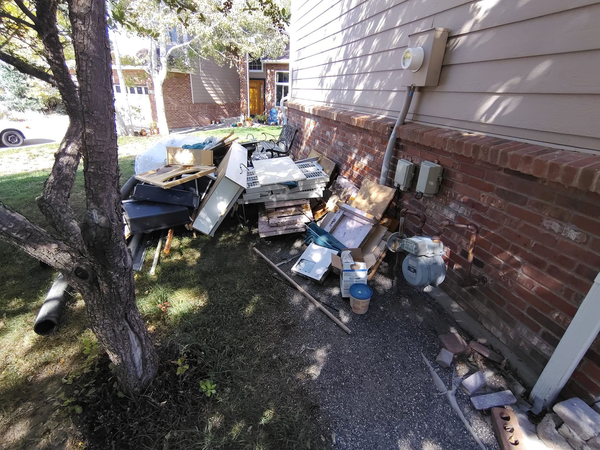 A pile of trash is sitting on the side of a house.