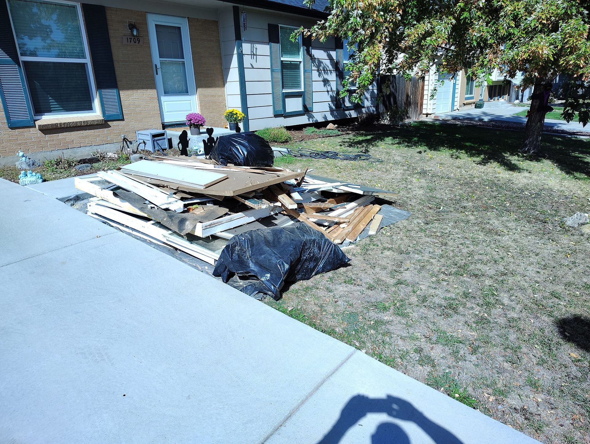 A pile of wood is sitting in front of a house