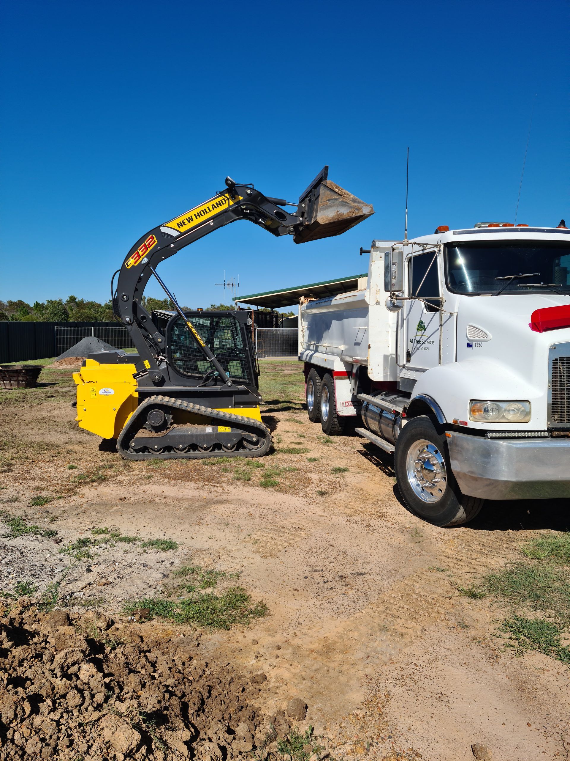 A Bulldozer Is Loading Dirt Into A Dump Truck — A1 Tree Service in Burnett, QLD