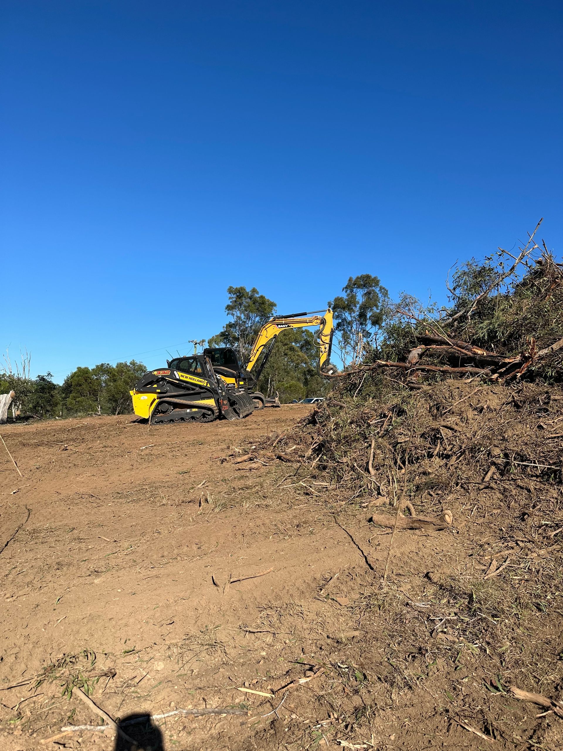 Excavator Clearing Tree Trunks On Dirt — A1 Tree Service in Kensington, QLD