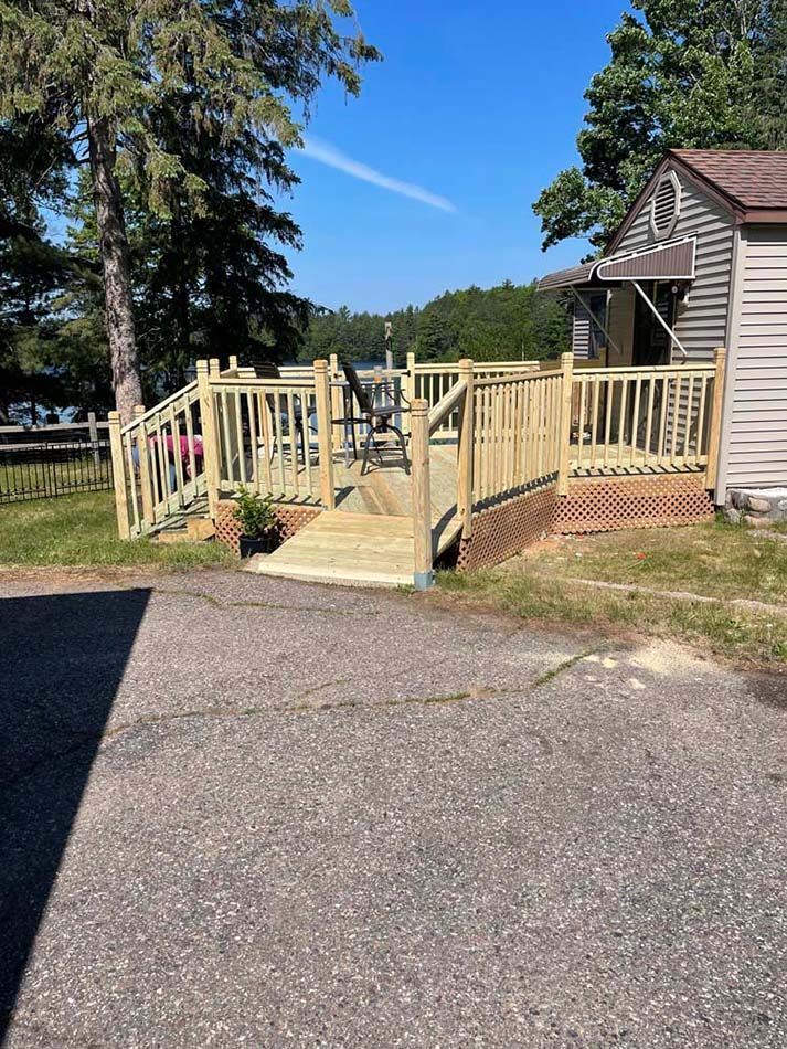 A wooden deck with stairs leading up to it next to a house.