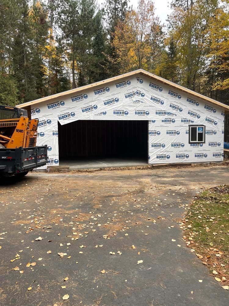 A truck is parked in front of a garage under construction.