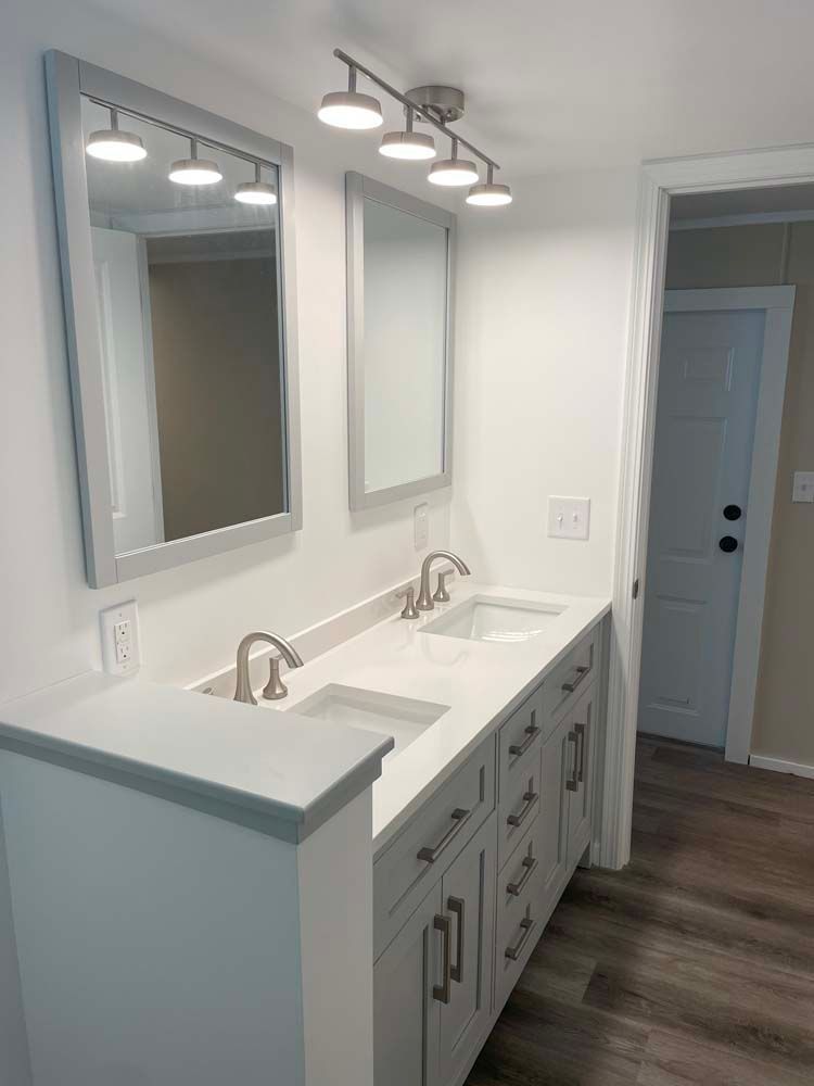 A bathroom with two sinks and two mirrors.