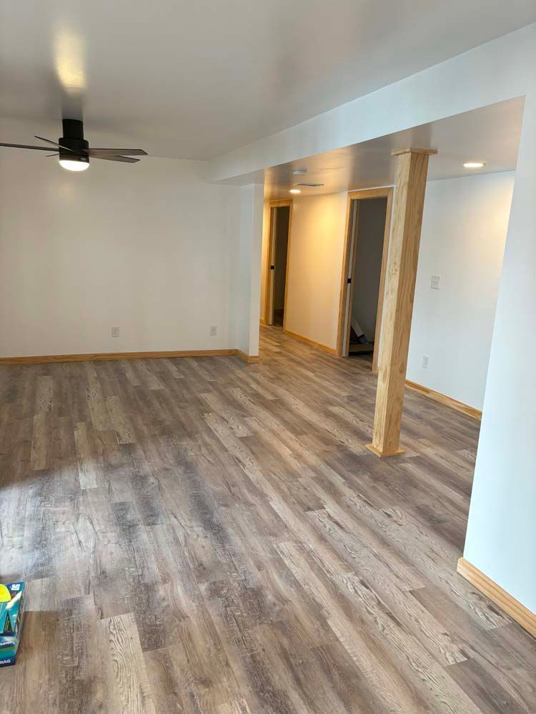 A living room with hardwood floors and a ceiling fan.