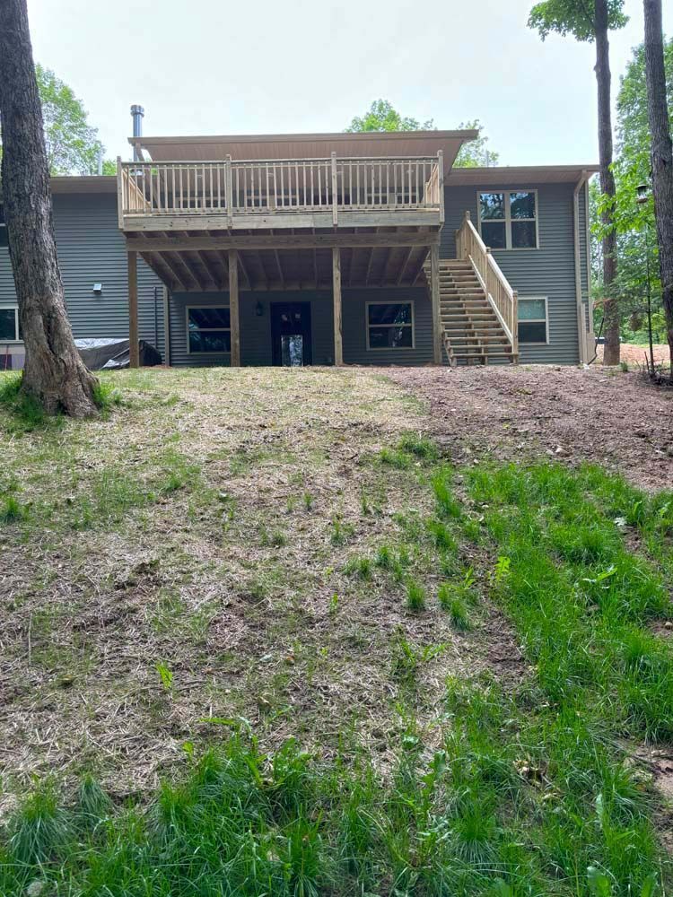 The back of a house with a large deck and stairs.