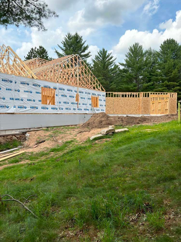 A house is being built in the middle of a grassy field.