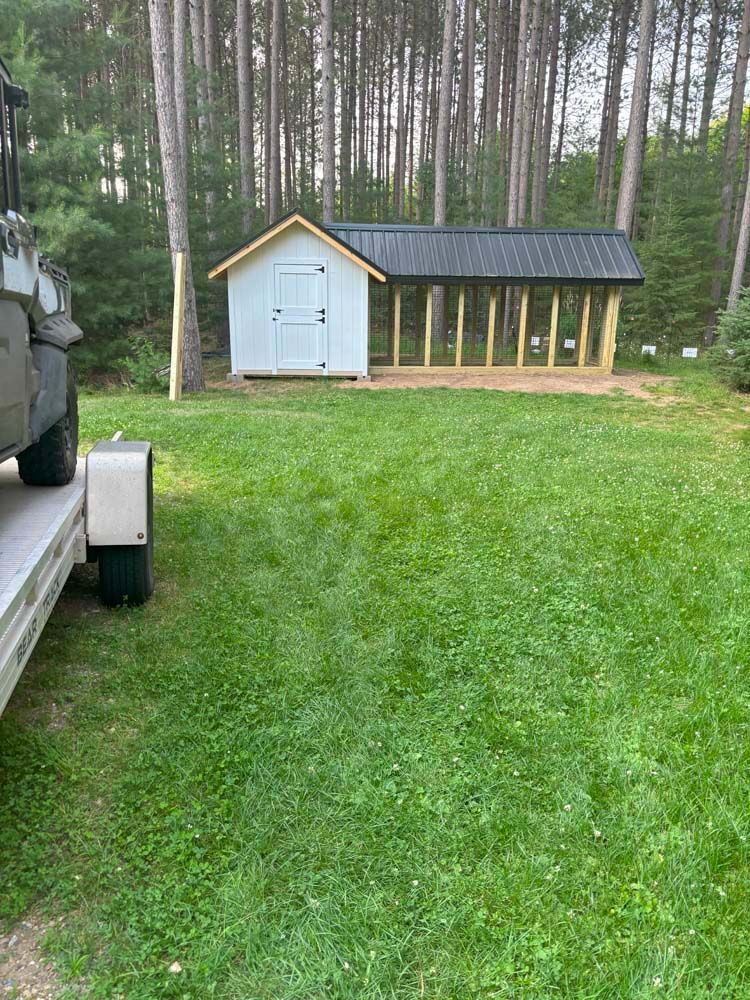 A shed is being built in the middle of a lush green field.
