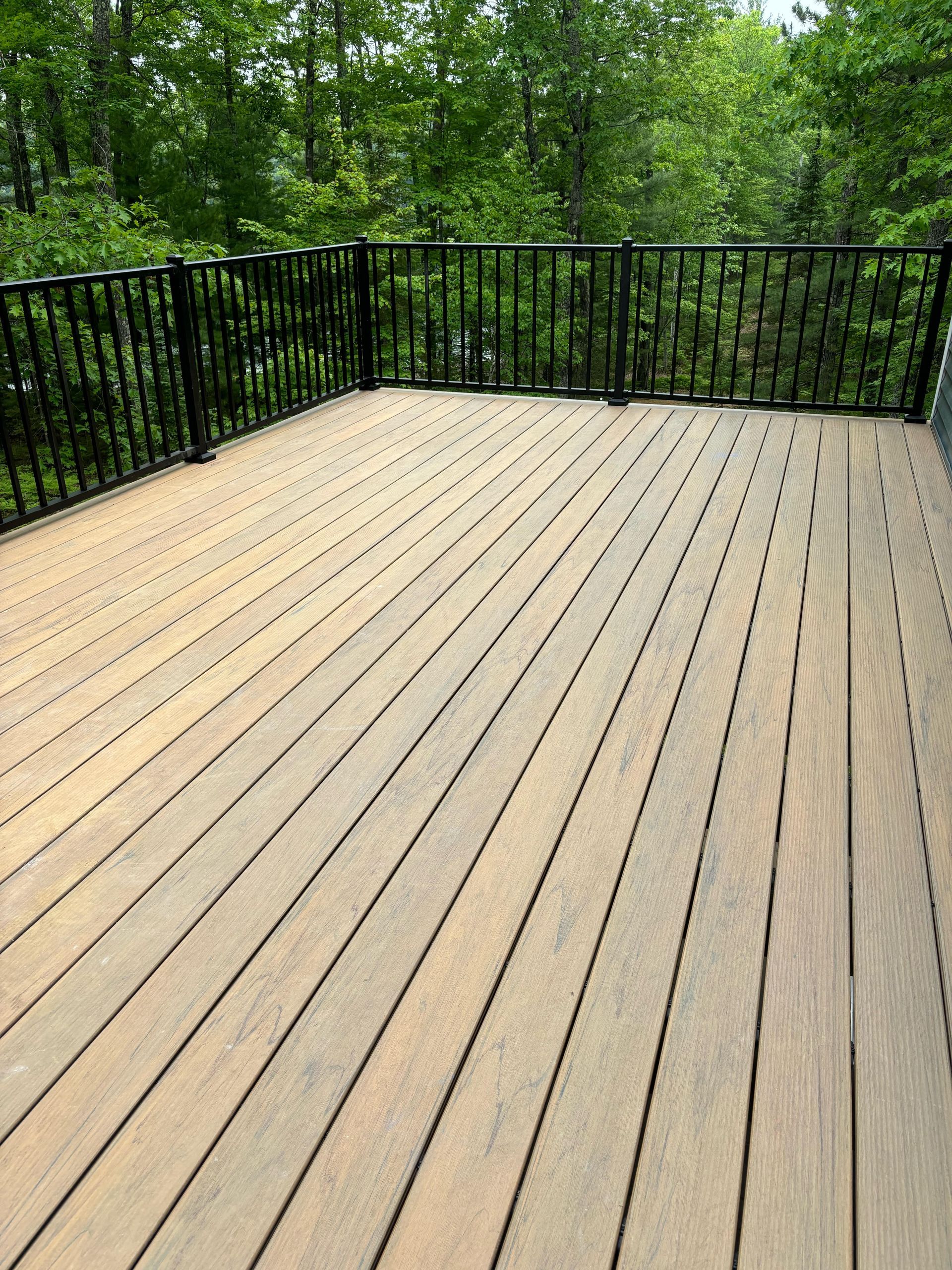 A blue house with a wooden deck in front of it
