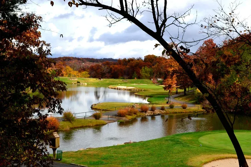 a golf course with a lake in the middle of it