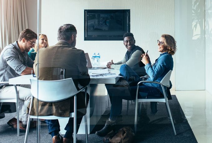 a group of people are sitting around a table with laptops depicting HR services