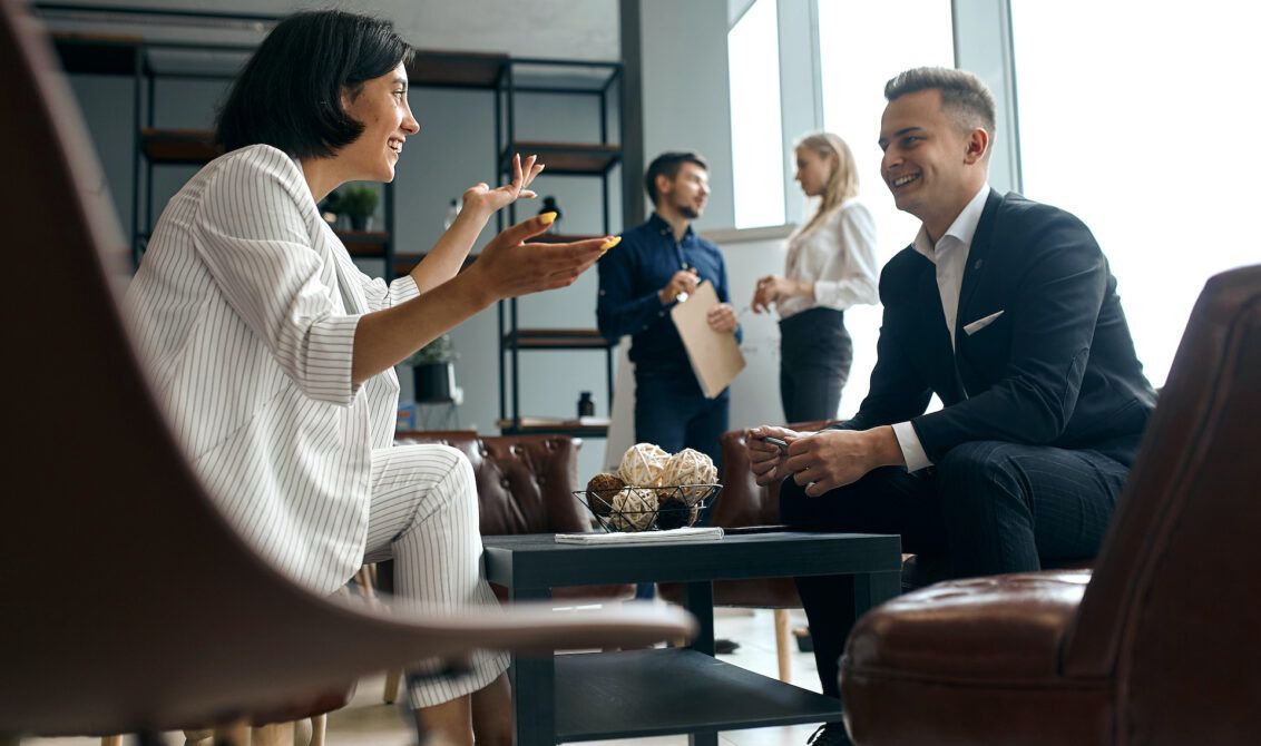 A group of people are sitting around a table having a conversation | Elgin, IL | 'I' in Team Series By IA Business Advisors