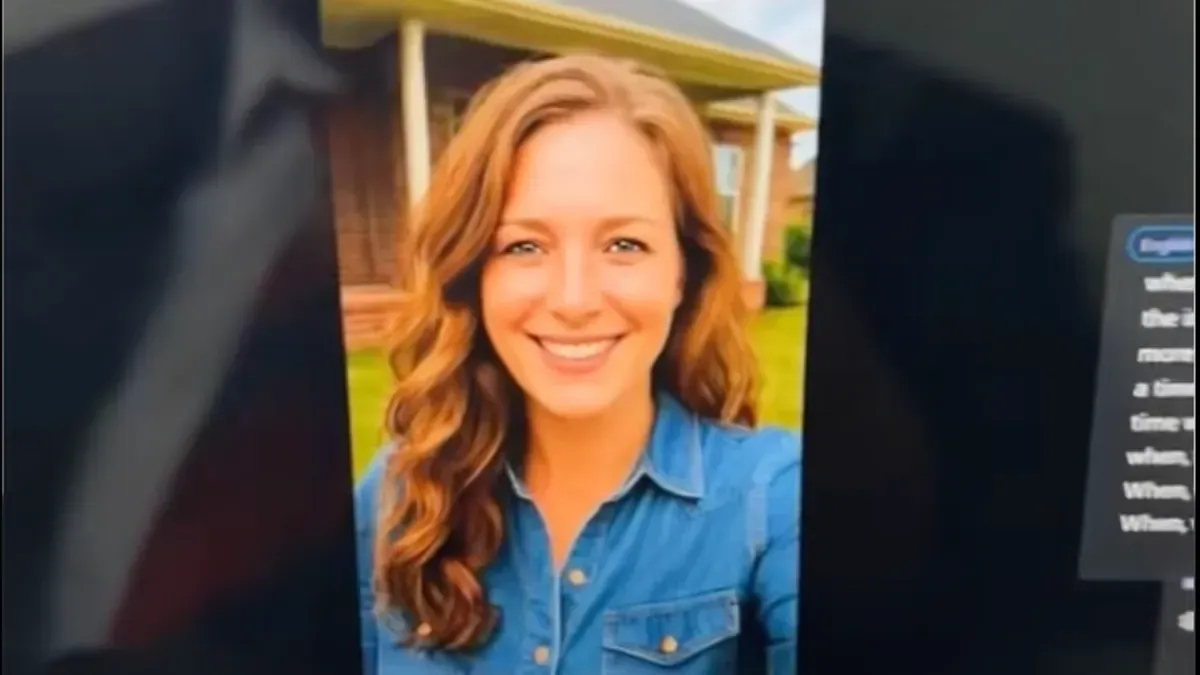 A man is sitting at a desk using a laptop computer.