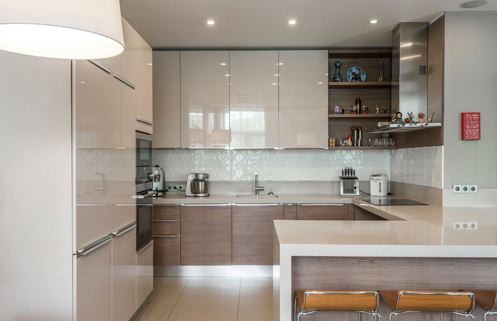 A kitchen with white cabinets and wooden counter tops and stools.
