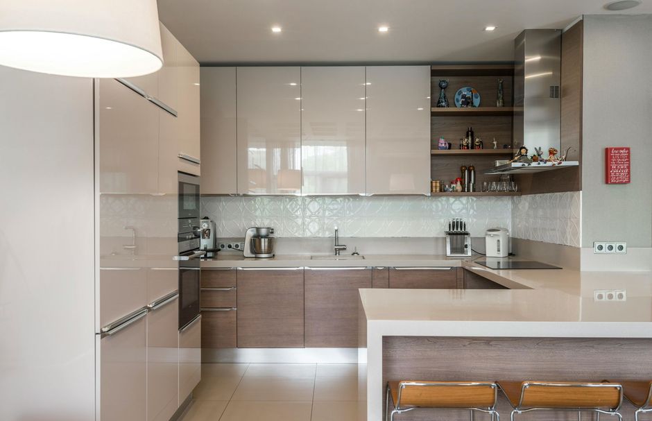A kitchen with white cabinets and wooden counter tops and stools.