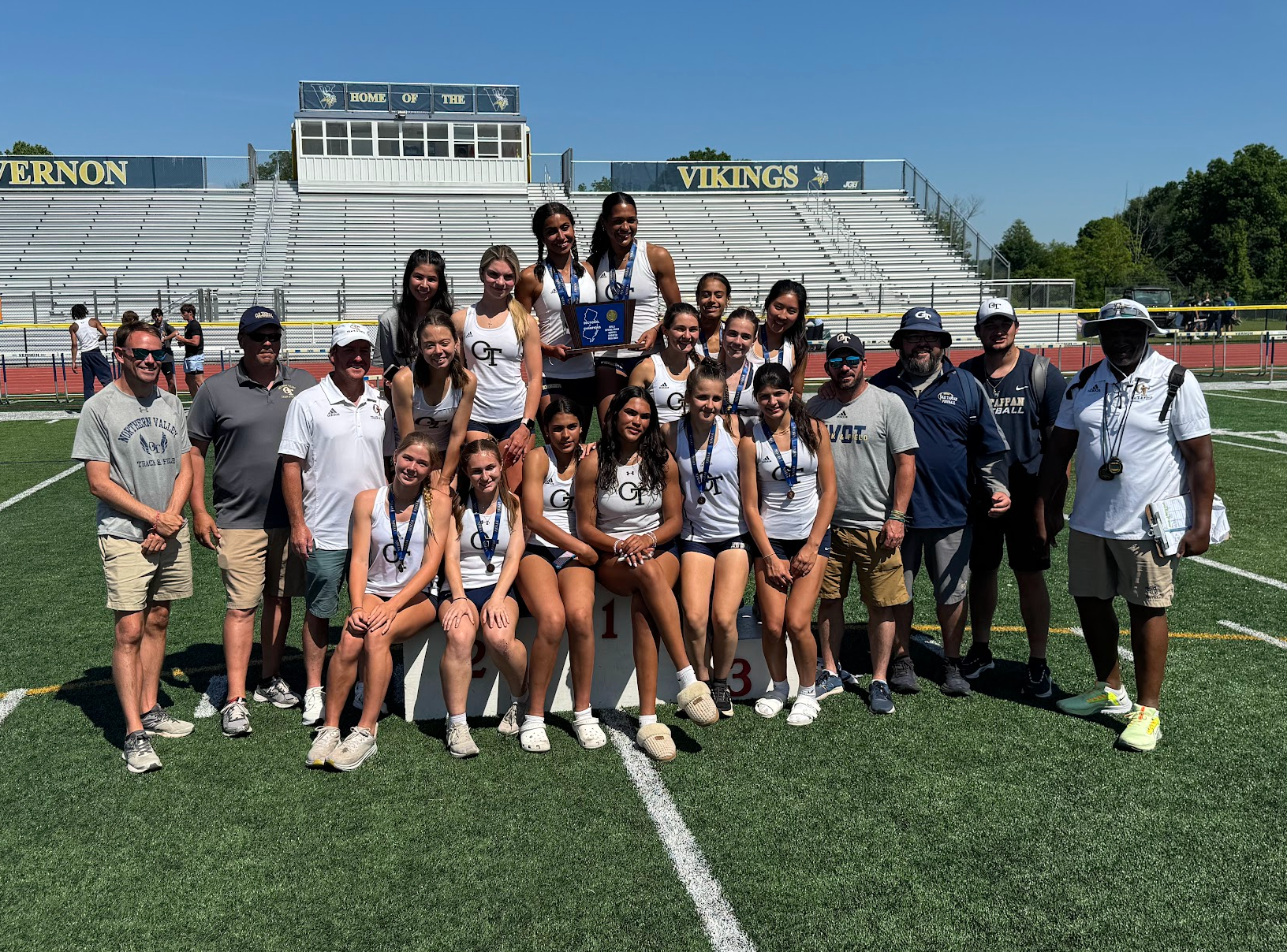 A group of people are posing for a picture on a football field.