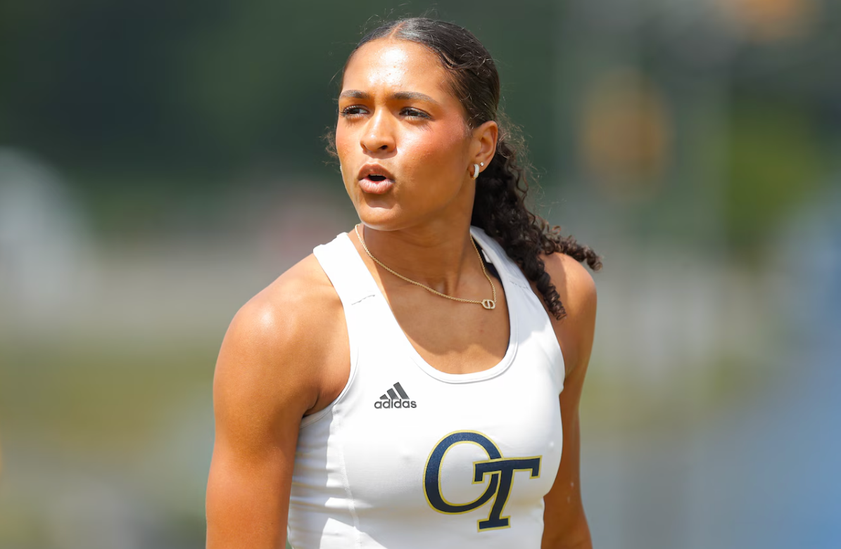 A woman is wearing a white tank top with the letter gt on it.