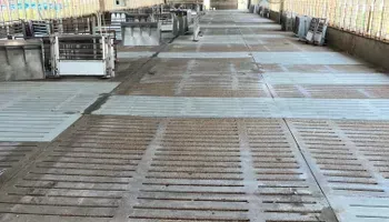 A long hallway in a building with a concrete floor.