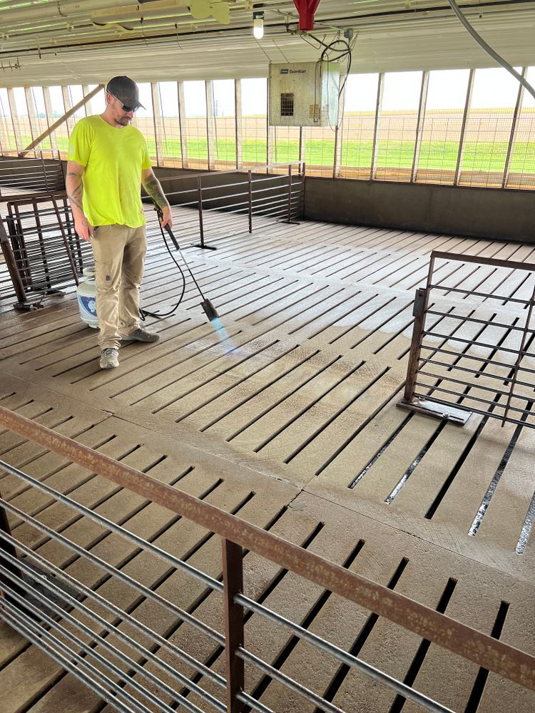 A man in a yellow shirt is cleaning the floor of a building