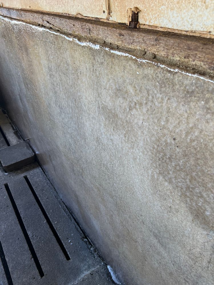 A close up of a concrete wall with a wooden trim.
